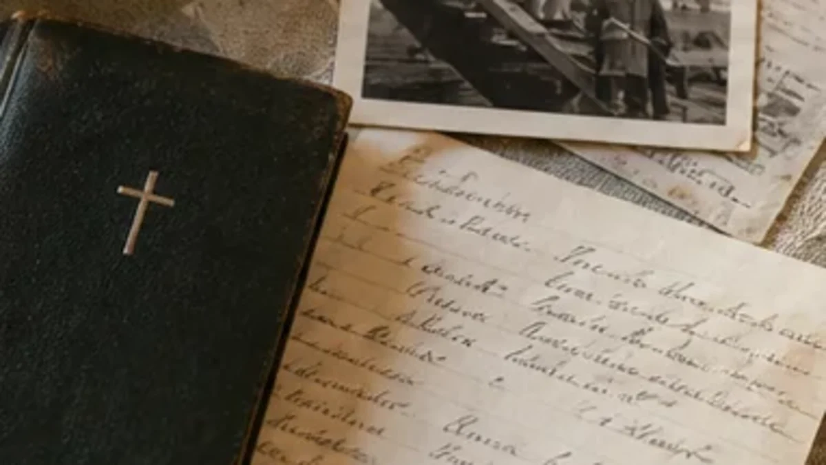 Old family photograph, handwritten paper, church booklet and ceramic dish on a table