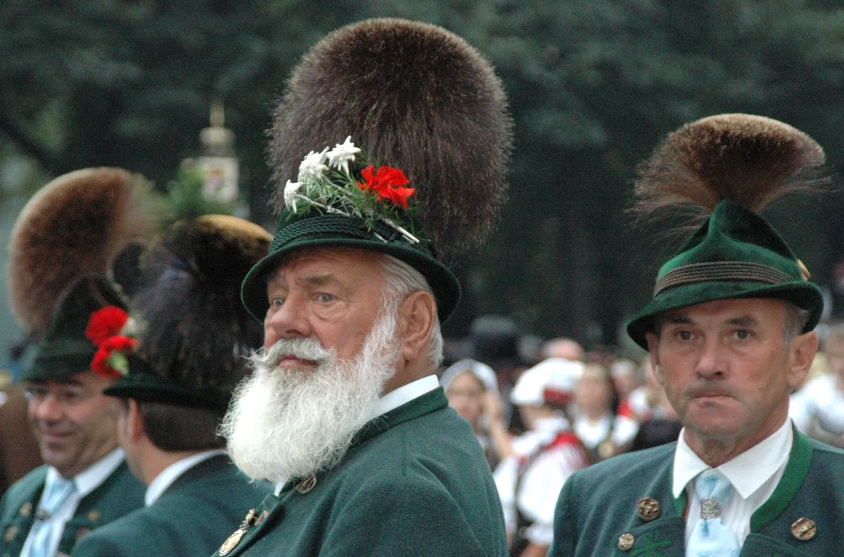 Bavarian men at Oktoberfest wearing green Trachten hats decorated with large Gamsbart plumes