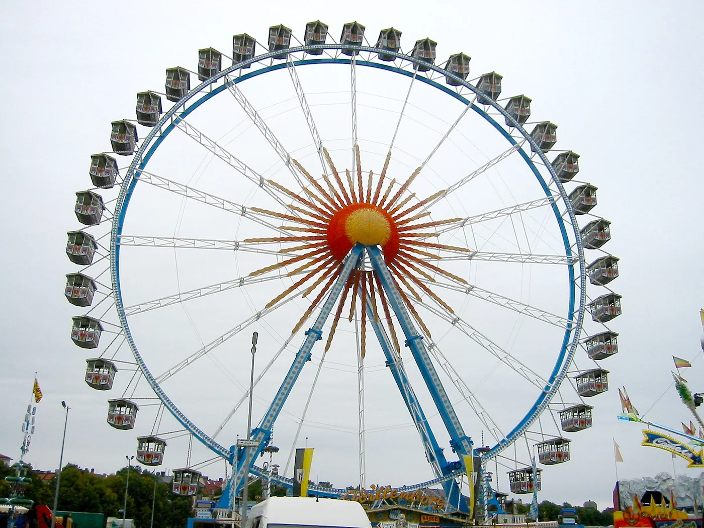 Festival ferris wheel rising above an Oktoberfest fairground
