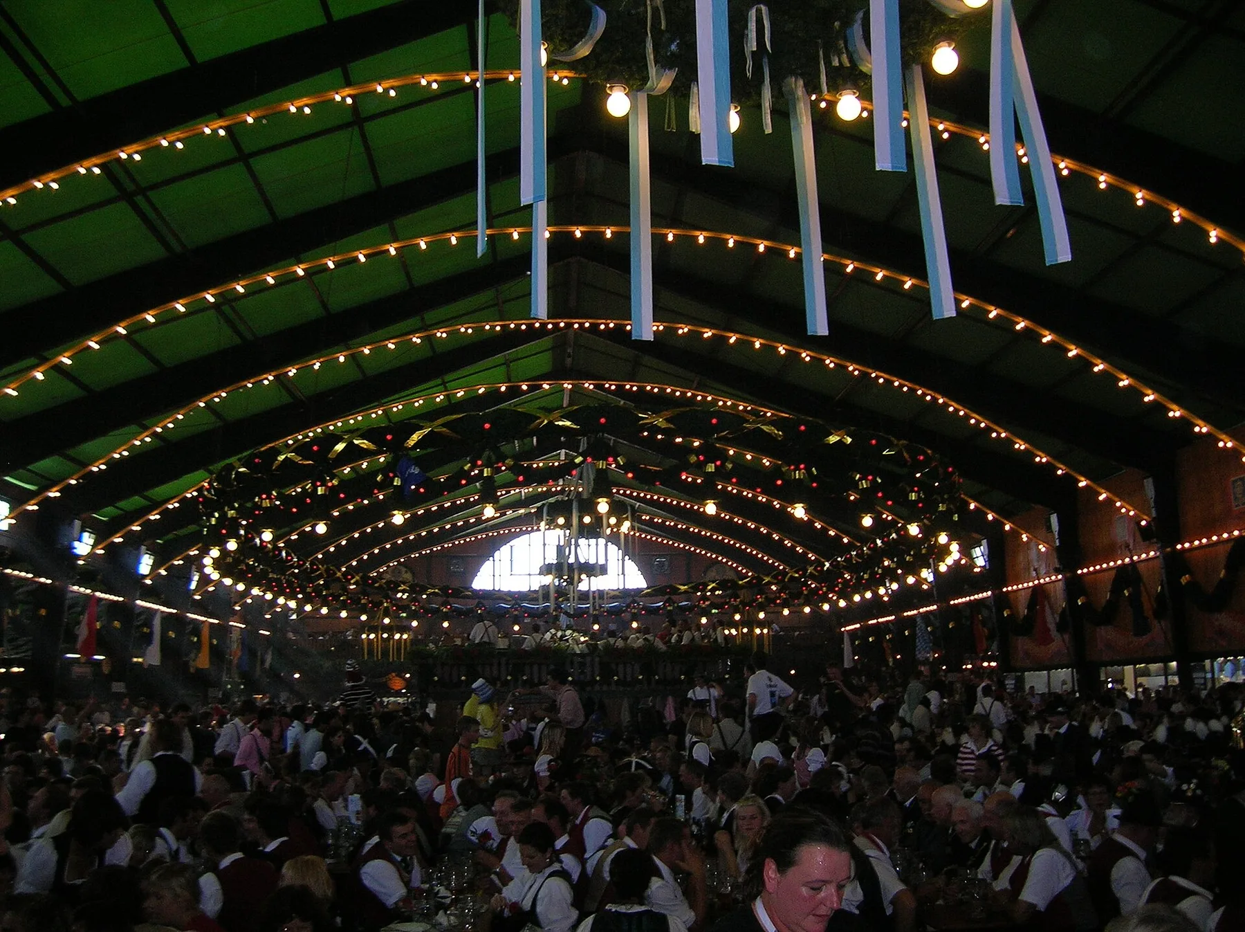 Long shared tables arranged inside a decorated Oktoberfest tent