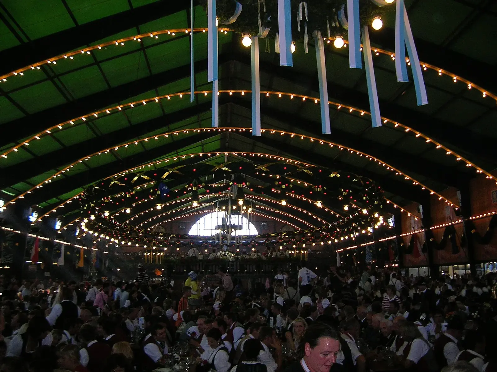 Visitors in lederhosen and dirndls seated inside the Augustiner tent at Munich Oktoberfest